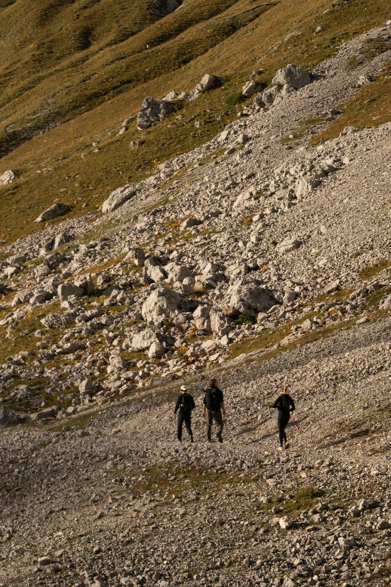 A group of people walking up a rocky hill